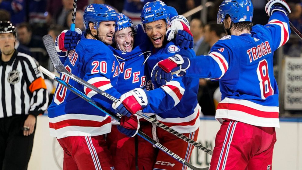 New York Rangers' Chris Kreider (20) celebrates with teammates K'Andre Miller (79) and Jacob Trouba (8) after scoring a goal during the second period of Game 2 of an NHL hockey Stanley Cup first-round playoff series against the Pittsburgh Penguins, T