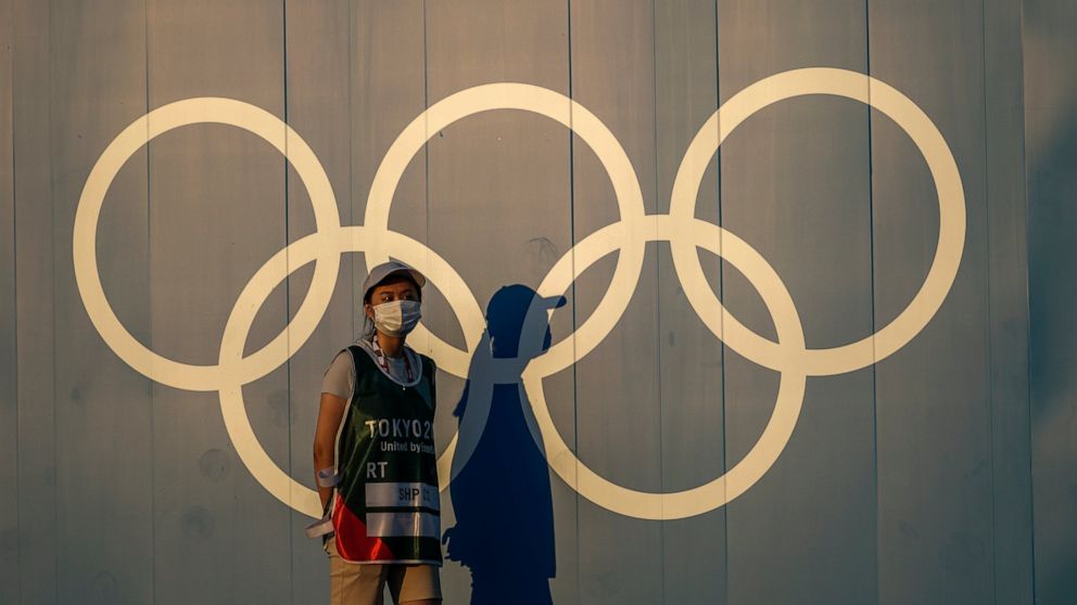 FILE - A volunteer walks past the Olympic rings ahead of the 2020 Summer Olympics, in Tokyo on July 22, 2021. Japan's northern city of Sapporo on Monday, June 6, 2022, rejected holding a referendum to give voters a choice over bidding for the 2030 Wi
