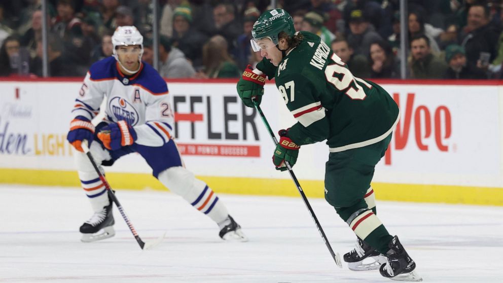 Minnesota Wild left wing Kirill Kaprizov (97) controls the puck against Edmonton Oilers defenseman Darnell Nurse (25) during the second period of an NHL hockey game Thursday, Dec. 1, 2022, in St. Paul, Minn. (AP Photo/Stacy Bengs)