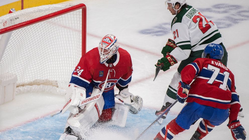 Minnesota Wild's Brandon Duhaime (21) scores on Montreal Canadiens goaltender Jake Allen as Canadiens' Jake Evans defends during the second period of an NHL hockey game, Tuesday, Oct. 25, 2022 in Montreal. (Graham Hughes/The Canadian Press via AP)