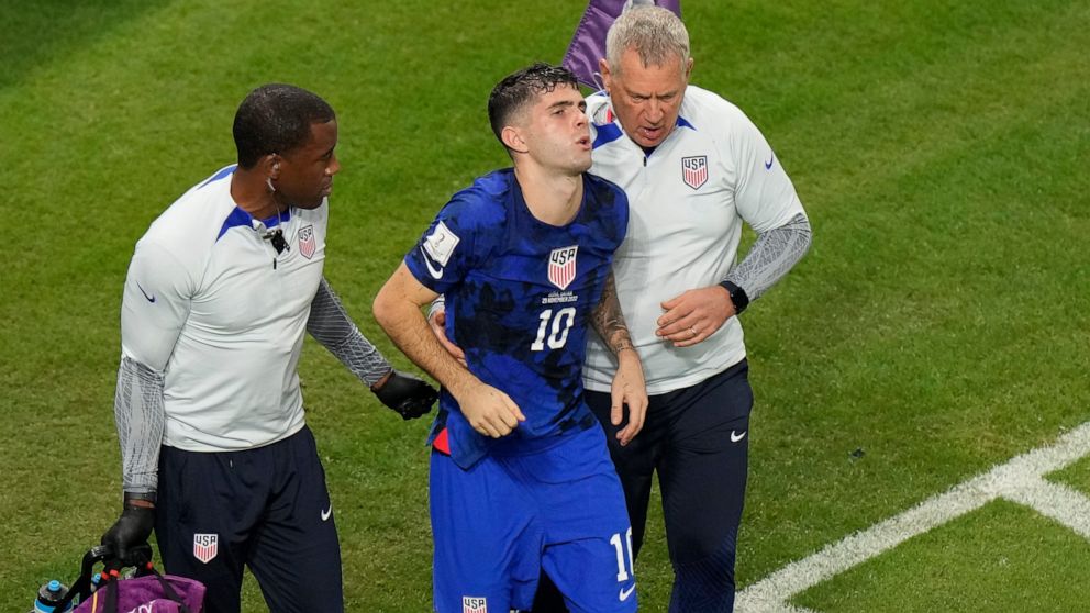 Christian Pulisic of the United States is helped by team doctors after he scoring his side's opening goal during the World Cup group B soccer match between Iran and the United States at the Al Thumama Stadium in Doha, Qatar, Tuesday, Nov. 29, 2022. (