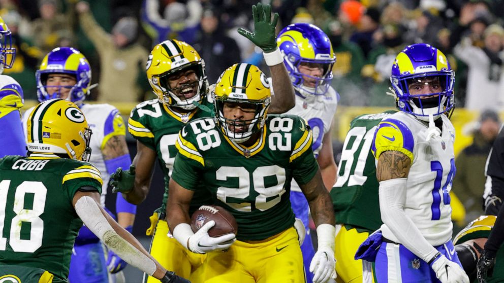 Green Bay Packers running back AJ Dillon (28) celebrates a touchdown against the Los angles Rams in the first half of an NFL football game in Green Bay, Wis. Monday, Dec. 19, 2022. (AP Photo/Mike Roemer)