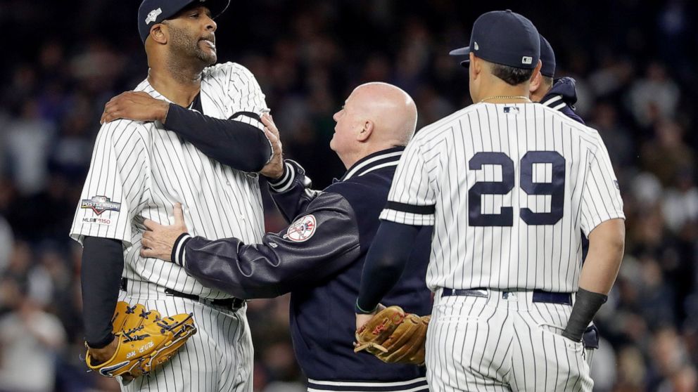 New York Yankees trainer Steve Donohue, center, checks on pitcher CC Sabathia during the eighth inning of Game 4 of baseball's American League Championship Series against the Houston Astros, Thursday, Oct. 17, 2019, in New York. (AP Photo/Frank Frank