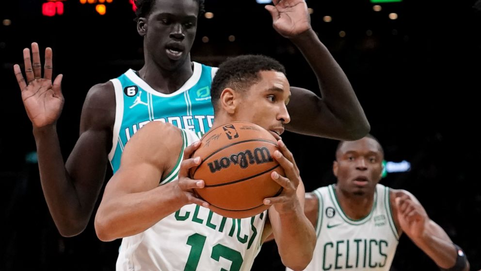 Boston Celtics' Malcolm Brogdon (13) drives toward the basket past Charlotte Hornets' JT Thor, back left, in the second half of a preseason NBA basketball game, Sunday, Oct. 2, 2022, in Boston. (AP Photo/Steven Senne)