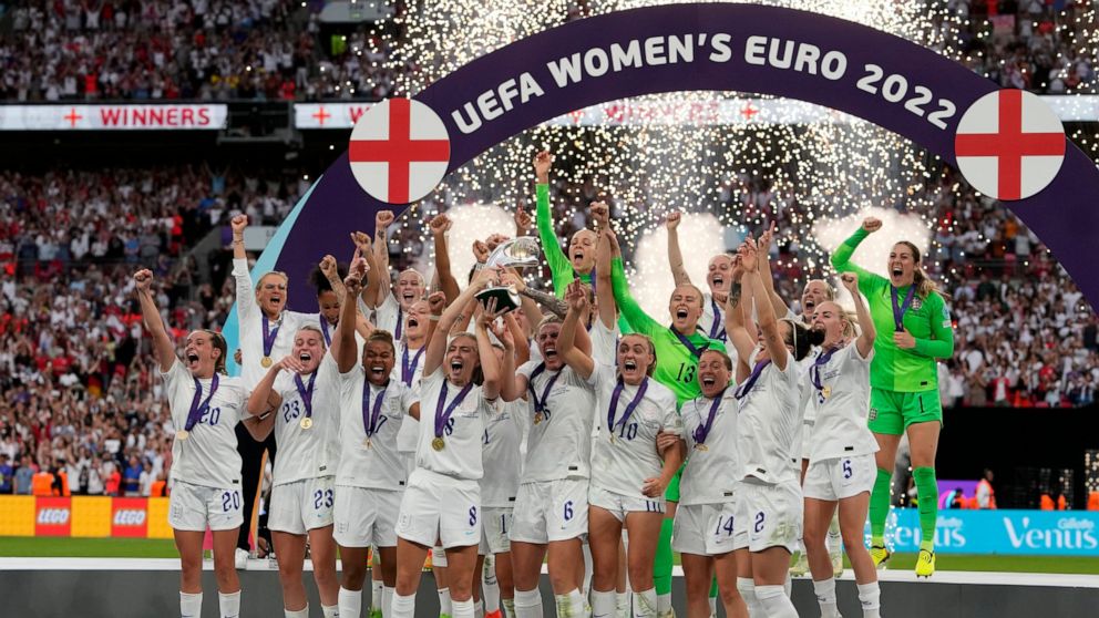 FILE - England's Leah Williamson, center left, and Millie Bright lift the trophy after winning the Women's Euro 2022 final soccer match between England and Germany at Wembley stadium in London, Sunday, July 31, 2022. England won 2-1. (AP Photo/Alessa