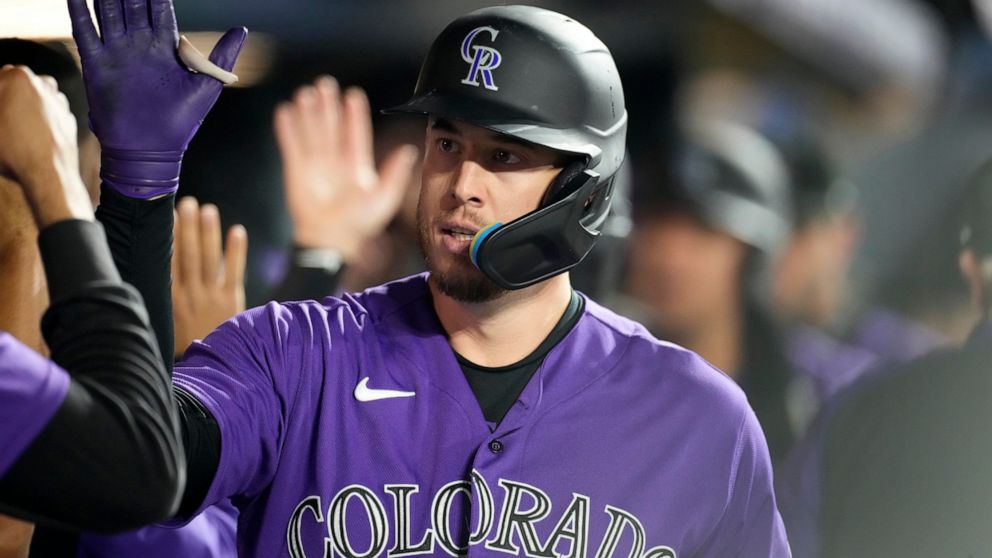 Colorado Rockies' C.J. Cron is congratulated as he returns to the dugut after hitting a three-run home run off Arizona Diamondbacks starting pitcher Madison Bumgarner during the sixth inning of a baseball game Saturday, Sept. 10, 2022, in Denver. (AP