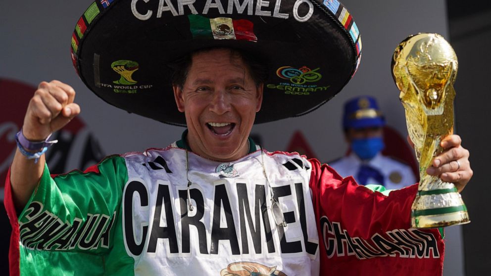 FILE - Mexico national soccer team fan Hector Chavez, also known as Caramelo, poses with a replica of the World Cup trophy in the Iztapalapa neighborhood of Mexico City, Sunday, Oct. 16, 2022. Super fan Caramelo claims Qatar will be the 10th World Cu