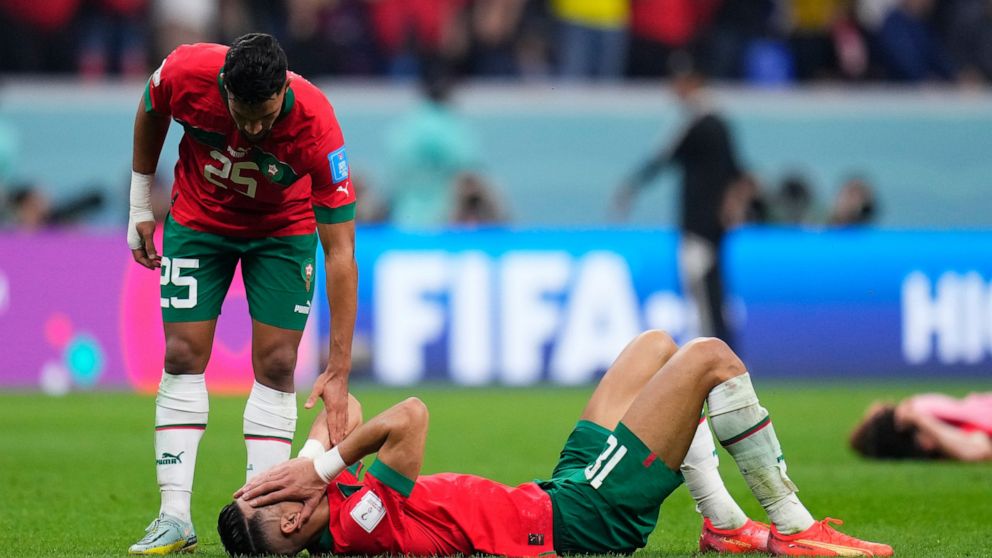 Morocco's Yahia Attiyat Allah consoles a teammate at the end of the World Cup semifinal soccer match between France and Morocco at the Al Bayt Stadium in Al Khor, Qatar, Wednesday, Dec. 14, 2022. France won 2-0 and will play Argentina in Sunday's fin