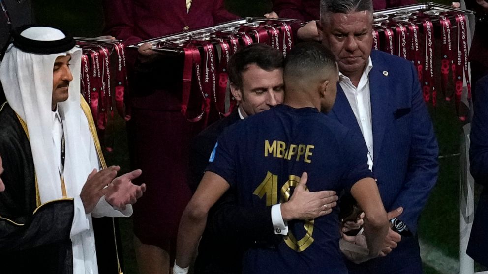 France's President Emmanuel Macron comforts France's Kylian Mbappe during the award ceremony of the World Cup at the Lusail Stadium in Lusail, Qatar, Sunday, Dec. 18, 2022. (AP Photo/Christophe Ena)