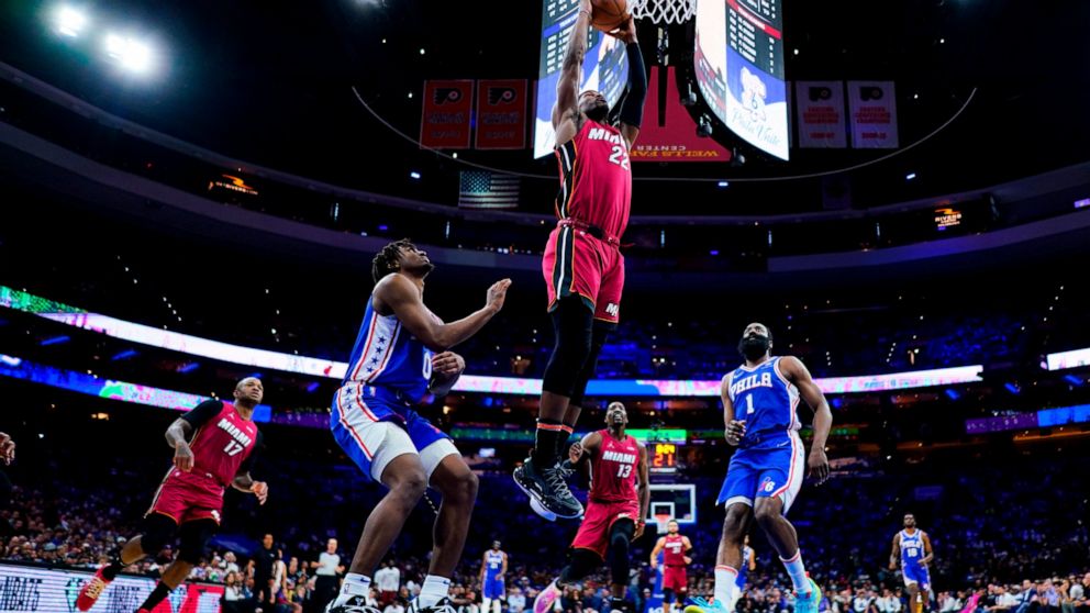 Miami Heat's Jimmy Butler dunks against Philadelphia 76ers' Tyrese Maxey (0) and James Harden (1) during the second half of Game 6 of an NBA basketball second-round playoff series, Thursday, May 12, 2022, in Philadelphia. (AP Photo/Matt Slocum)