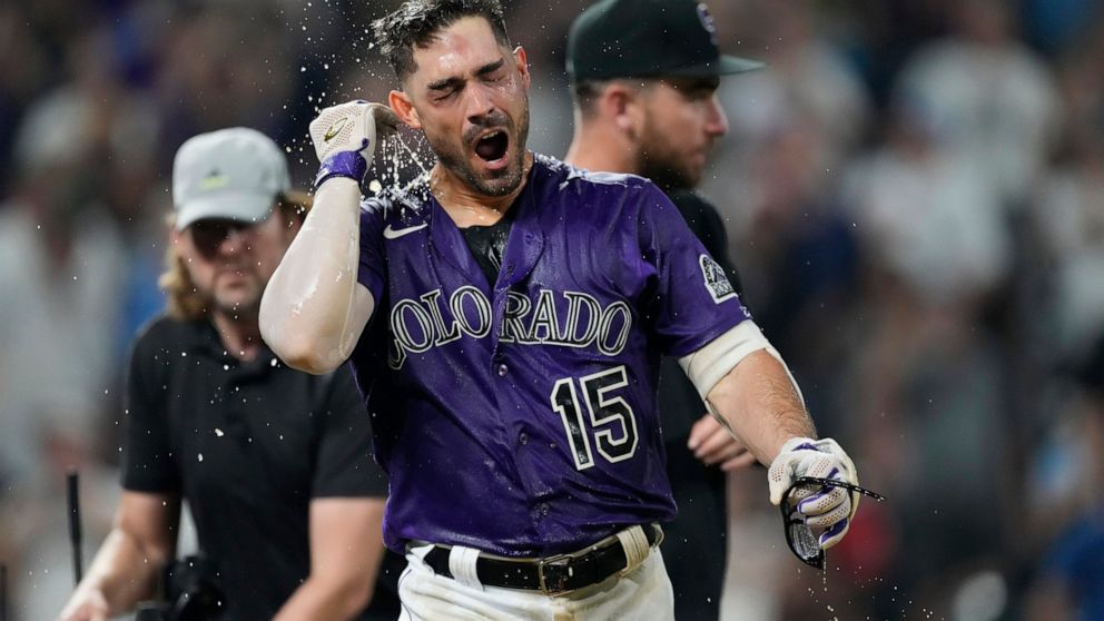 Colorado Rockies' Randal Grichuk reacts to having been doused by teammates after crossing home plate on a three-run home run off Milwaukee Brewers relief pitcher Taylor Rogers during the 10th inning of a baseball game Tuesday, Sept. 6, 2022, in Denve