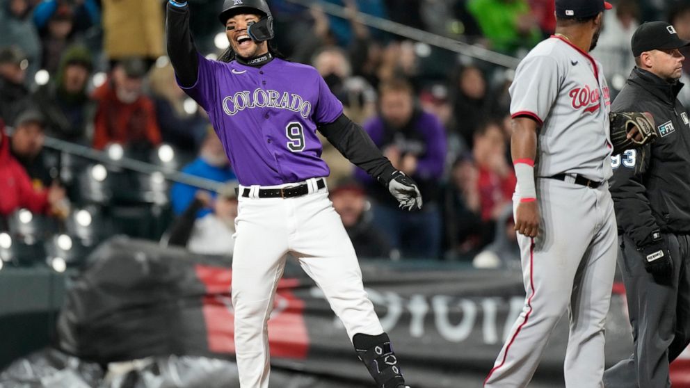 Colorado Rockies' Connor Joe gestures to the dugout after reaching third base with a triple that brought in two runs in the fourth inning of a baseball game against the Washington Nationals, Wednesday, May 4, 2022, in Denver. (AP Photo/David Zalubowski)