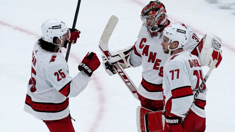 Carolina Hurricanes goaltender Frederik Andersen is congratulated by Ethan Bear (25) and Tony DeAngelo (77) after shutting out the Boston Bruins 6-0 in an NHL hockey game, Thursday, Feb. 10, 2022. (AP Photo/Charles Krupa)