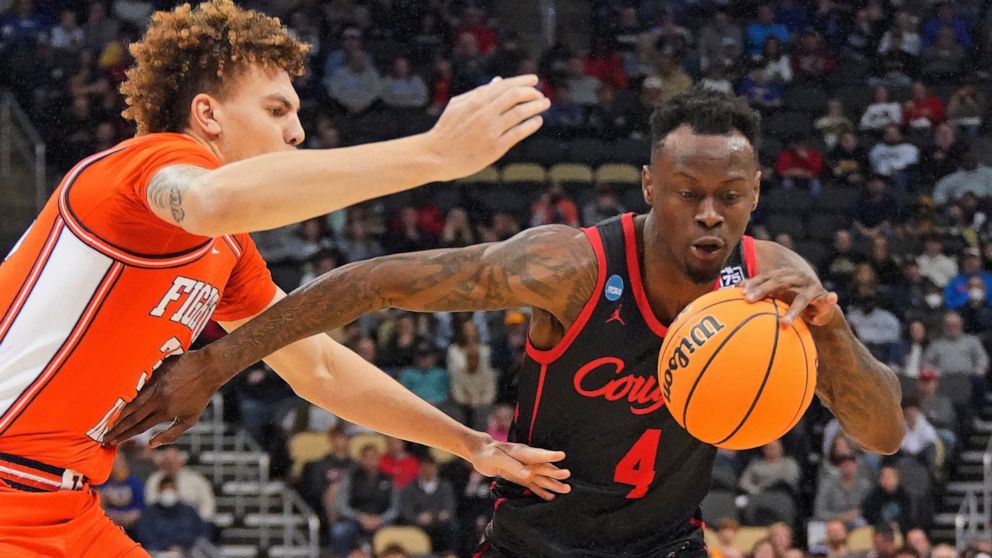 Houston 's Taze Moore (4) dribbles around Illinois 's Coleman Hawkins during the first half of a college basketball game in the second round of the NCAA tournament in Pittsburgh, Sunday, March 20, 2022. Houston won 68-53. (AP Photo/Gene J. Puskar)