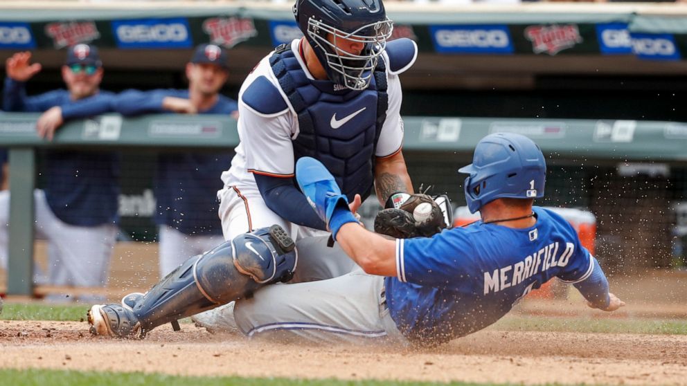 Minnesota Twins catcher Gary Sanchez tags out Toronto Blue Jays' Whit Merrifield who tags from third on a sacrifice fly by Cavan Biggio in the tenth inning of a baseball game Sunday, Aug. 7, 2022, in Minneapolis. The play was overturned on review due