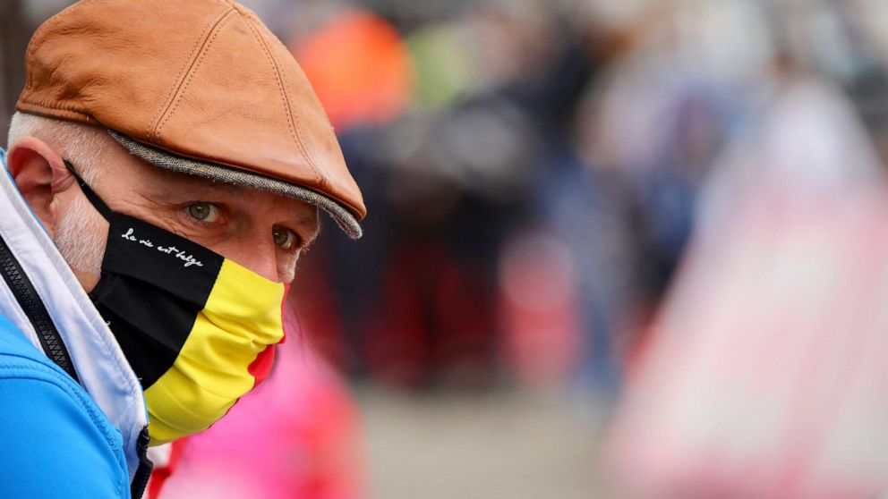 A spectator wears a protective mask as he watches the Belgian cycling classic and UCI World Tour race Fleche Wallonne, in Huy, Belgium, Wednesday, Sept. 30, 2020. (AP Photo/Olivier Matthys)
