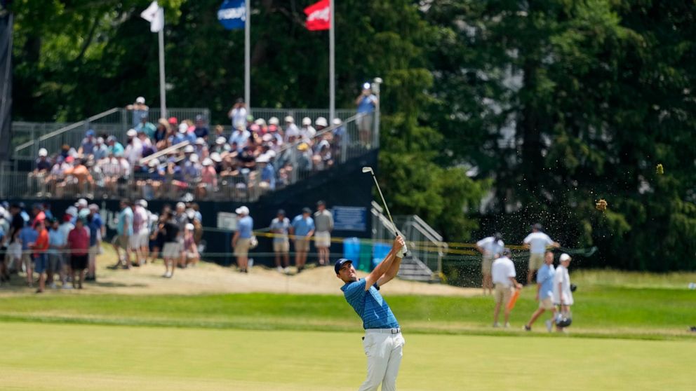 Scottie Scheffler watches his shot on the 18th hole during the second round of the U.S. Open golf tournament at The Country Club, Friday, June 17, 2022, in Brookline, Mass. (AP Photo/Charlie Riedel)