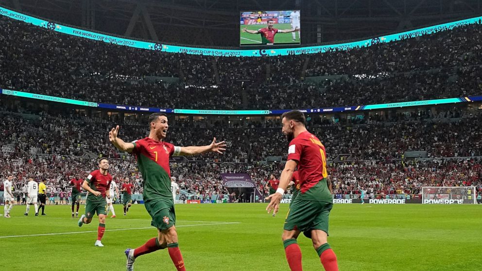 Portugal's Cristiano Ronaldo celebrates his side's opening goal with Portugal's Bruno Fernandes during the World Cup group H soccer match between Portugal and Uruguay, at the Lusail Stadium in Lusail, Qatar, Monday, Nov. 28, 2022. (AP Photo/Themba Hadebe)