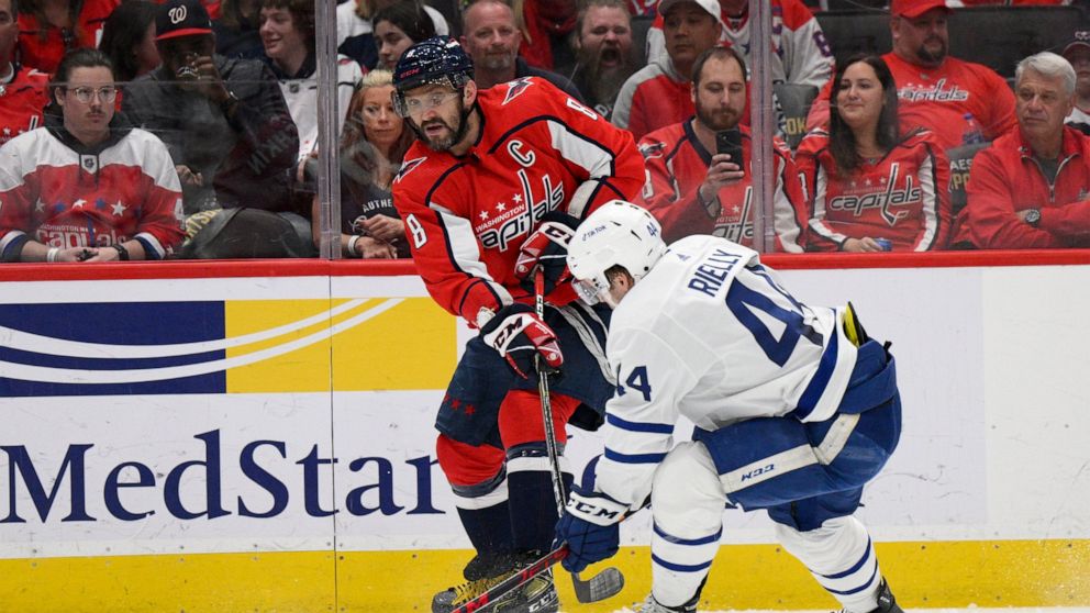Washington Capitals left wing Alex Ovechkin (8) passes the puck against Toronto Maple Leafs defenseman Morgan Rielly (44) during the first period of an NHL hockey game, Sunday, April 24, 2022, in Washington. (AP Photo/Nick Wass)