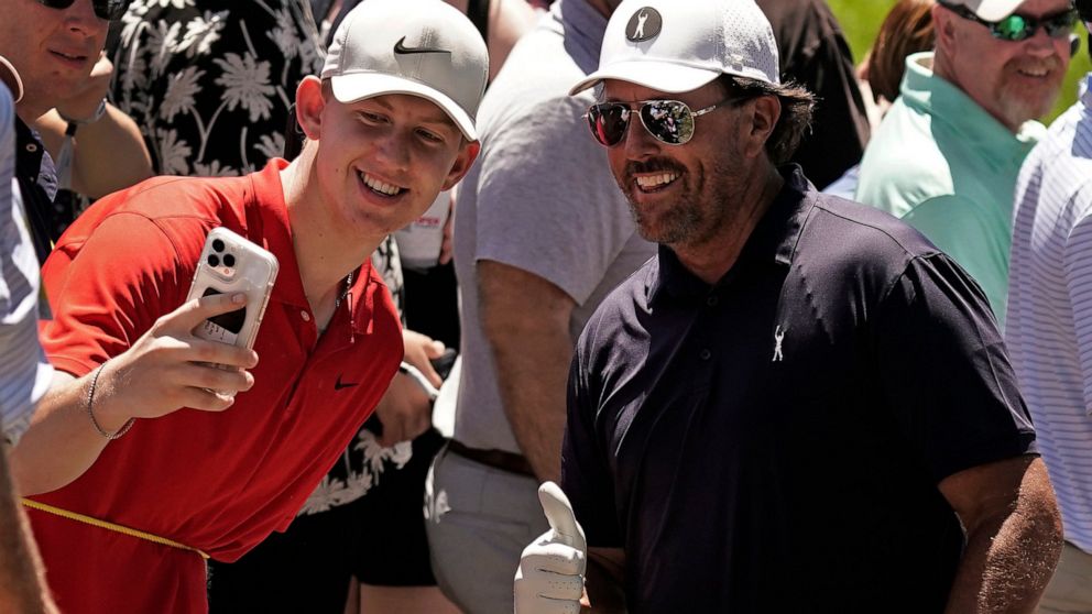 Phil Mickelson poses for a photo with a fan during a practice round ahead of the U.S. Open golf tournament, Tuesday, June 14, 2022, at The Country Club in Brookline, Mass. (AP Photo/Charlie Riedel)