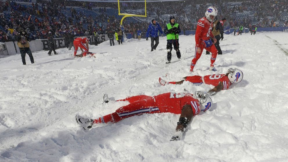 FILE - Buffalo Bills players make snow angels in the snow after defeating the Indianapolis Colts after an NFL football game, on Sunday, Dec. 10, 2017, in Orchard Park, N.Y. The NFL is monitoring the weather and has contingency plans in place in the e