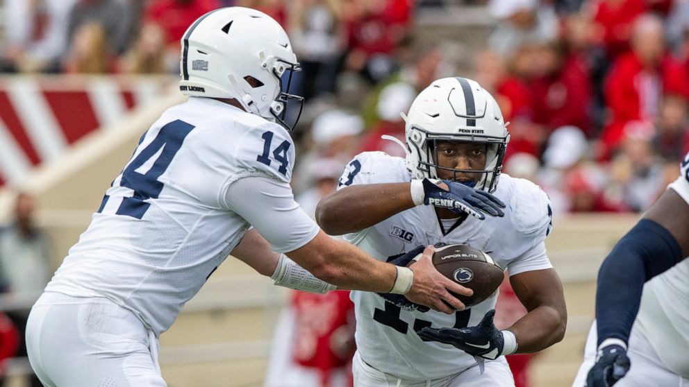 Penn State quarterback Sean Clifford (14) hands off the ball to running back Kaytron Allen (13) in the backfield during the first half of an NCAA college football game against Indiana, Saturday, Nov. 5, 2022, in Bloomington, Ind. (AP Photo/Doug McSch