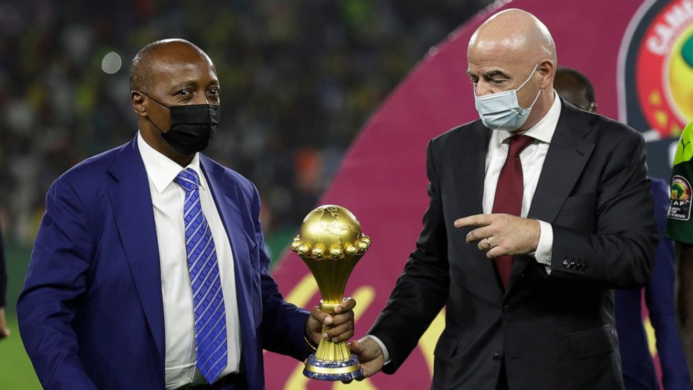 FILE- CAF President Patrice Motsepe, left, and FIFA President Gianni Infantino hold the African Cup of Nations 2022 trophy after the final soccer match between Senegal and Egypt at the Olembe stadium in Yaounde, Cameroon, on Feb. 6, 2022. (AP Photo/S