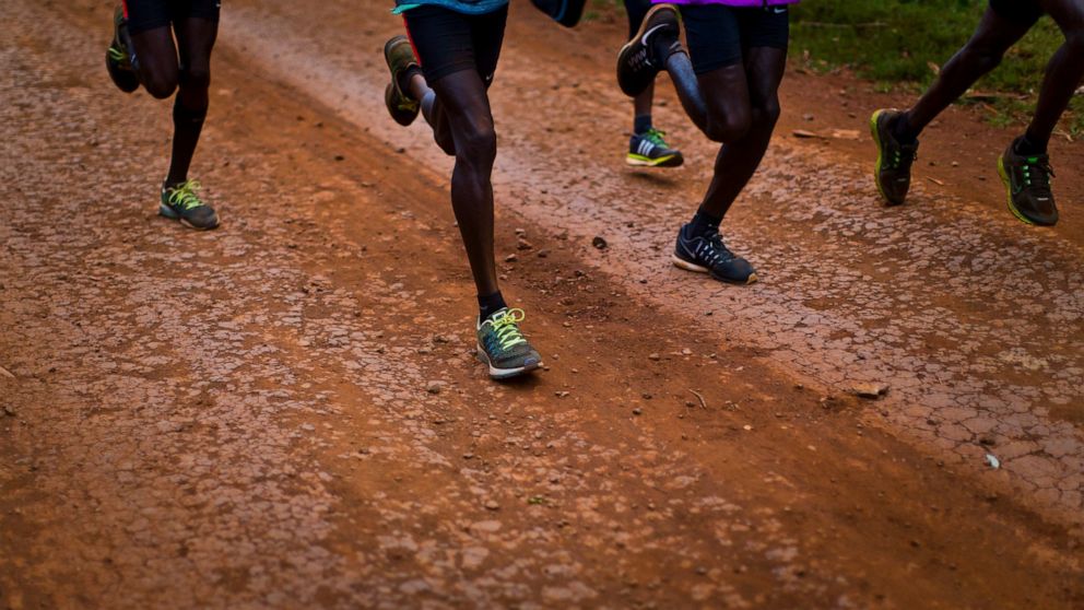 FILE - Kenyan athletes train together just after dawn on a dusty track in Kaptagat Forest in western Kenya, on Jan. 30, 2016. The threat of an imminent ban by track and field governing body World Athletics, which would likely have repercussions for a