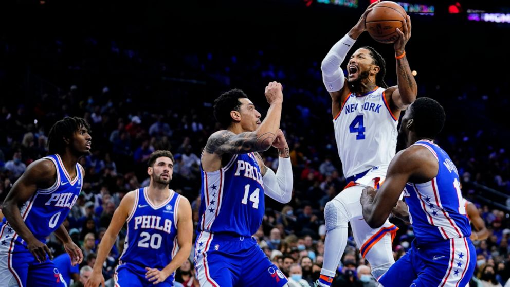 New York Knicks' Derrick Rose (4) goes up for a shot against Philadelphia 76ers' Shake Milton, from right, Danny Green, Georges Niang and Tyrese Maxey during the first half of an NBA basketball game, Monday, Nov. 8, 2021, in Philadelphia. (AP Photo/M