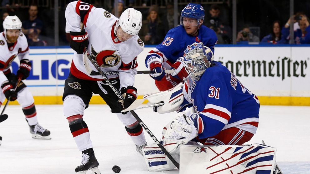 New York Rangers goalie Igor Shesterkin (31) stops Ottawa Senators left wing Tim Stutzle (18) as Rangers defenseman Adam Fox (23) assists Shesterkin during the first period of an NHL hockey game Friday, Dec. 2, 2022, in New York. (AP Photo/John Munson)