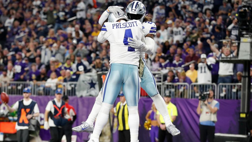 Dallas Cowboys running back Ezekiel Elliott celebrates with teammate quarterback Dak Prescott (4) after scoring on a 1-yard touchdown run during the second half of an NFL football game, Sunday, Nov. 20, 2022, in Minneapolis. (AP Photo/Bruce Kluckhohn)