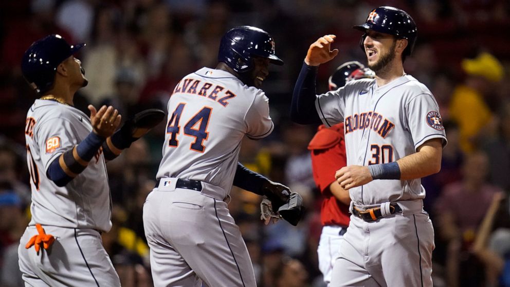 Houston Astros' Kyle Tucker (30) is congratulated by Yordan Alvarez (44) and Yuli Gurriel, left, after his grand slam during the fourth inning of the team's baseball game against the Boston Red Sox at Fenway Park, Tuesday, May 17, 2022, in Boston. (A