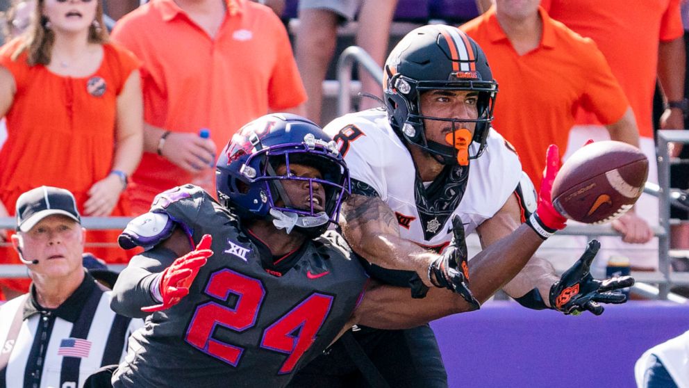 TCU cornerback Josh Newton (24) deflects a pass intended for Oklahoma State wide receiver Braydon Johnson (8) during the first half of an NCAA college football game in Fort Worth, Texas, Saturday, Oct. 15, 2022. (AP Photo/Sam Hodde)