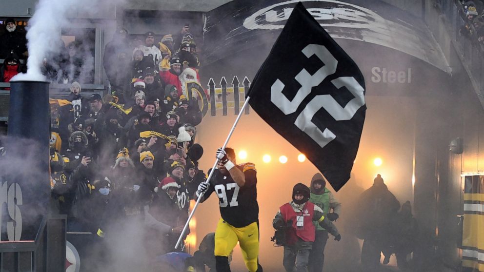 Pittsburgh Steelers defensive tackle Cameron Heyward (97) carries a banner with the uniform number of Pittsburgh Steelers' Franco Harris as he is introduced before an NFL football game against the Las Vegas Raiders in Pittsburgh, Saturday, Dec. 24, 2