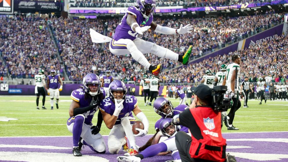 Minnesota Vikings safety Camryn Bynum (24) celebrates with teammates after intercepting a pass during the second half of an NFL football game against the New York Jets, Sunday, Dec. 4, 2022, in Minneapolis. The Vikings won 27-22. (AP Photo/Bruce Kluc