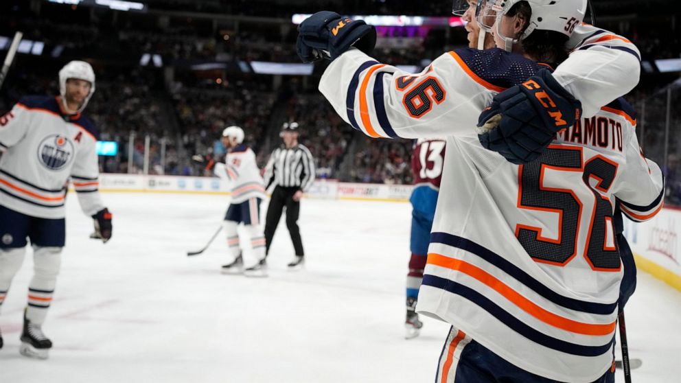 Edmonton Oilers right wing Kailer Yamamoto, front, is congratulated after scoring a goal by center Connor McDavid in the second period of an NHL hockey game against the Colorado Avalanche, Monday, March 21, 2022, in Denver. (AP Photo/David Zalubowski)