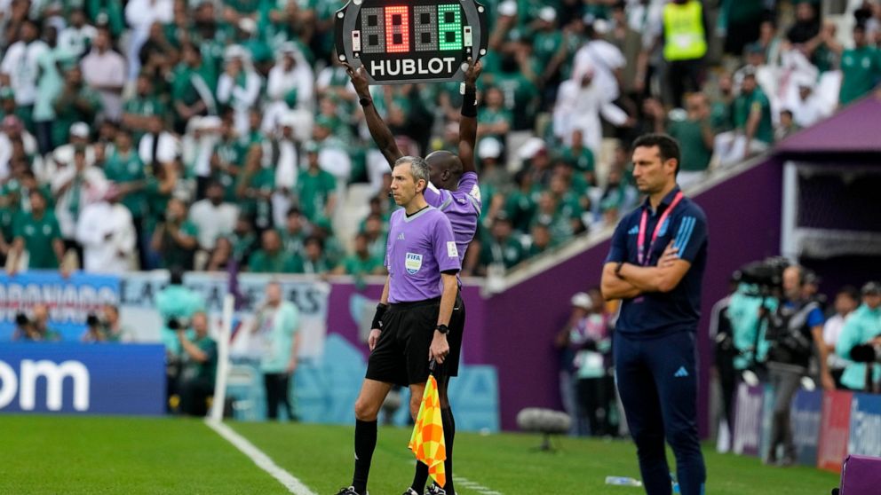 The referee assistant shows 8 minutes overtime during the World Cup group C soccer match between Argentina and Saudi Arabia at the Lusail Stadium in Lusail, Qatar, Tuesday, Nov. 22, 2022. (AP Photo/Natacha Pisarenko)