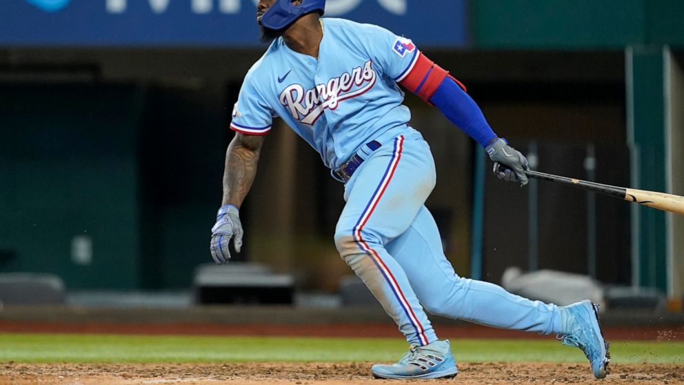 Texas Rangers' Adolis Garcia follows through on a ground out that scored Marcus Semien in the eighth inning of a baseball game in Arlington, Texas, Sunday, Aug. 28, 2022. (AP Photo/Tony Gutierrez)