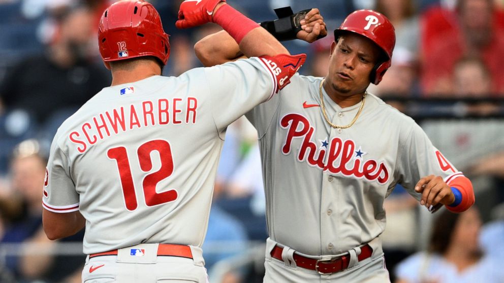 Philadelphia Phillies' Kyle Schwarber (12) celebrates his two-run home run with Yairo Munoz, right, during the third inning of the team's baseball game against the Washington Nationals, Thursday, June 16, 2022, in Washington. (AP Photo/Nick Wass)