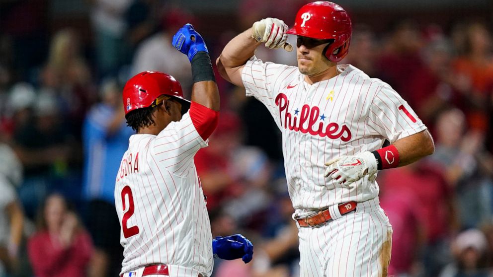 Philadelphia Phillies' J.T. Realmuto, right, and Jean Segura celebrate after Realmuto's home run against Washington Nationals pitcher Patrick Corbin during the sixth inning of a baseball game, Friday, Sept. 9, 2022, in Philadelphia. (AP Photo/Matt Slocum)