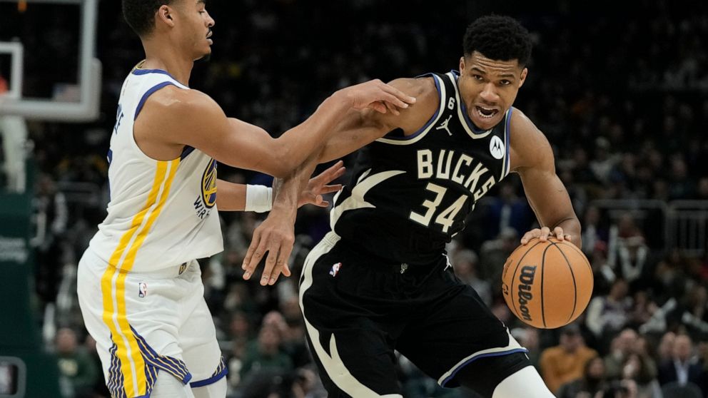 Milwaukee Bucks' Giannis Antetokounmpo is fouled by Golden State Warriors' Jordan Poole during the second half of an NBA basketball game Tuesday, Dec. 13, 2022, in Milwaukee. (AP Photo/Morry Gash)