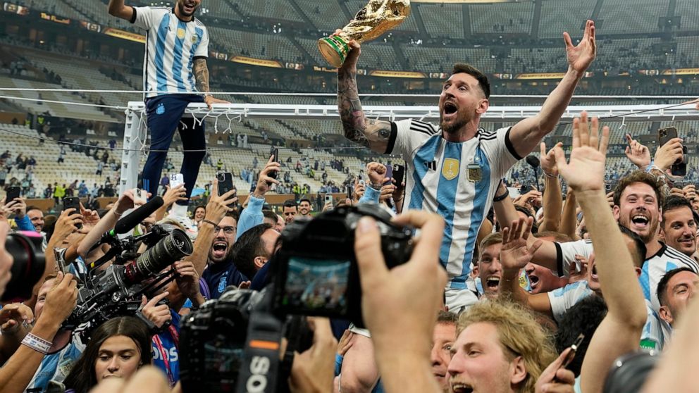 FILE - Argentina's Lionel Messi celebrates with the trophy in front of fans after winning the World Cup final soccer match between Argentina and France at the Lusail Stadium in Lusail, Qatar, Dec. 18, 2022. A World Cup that ended with Lionel Messi fi
