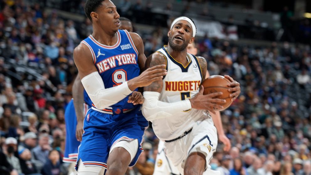 Denver Nuggets forward Will Barton, right, is defended by New York Knicks guard RJ Barrett during the second half of an NBA basketball game Tuesday, Feb. 8, 2022, in Denver. The Nuggets won 132-115. (AP Photo/David Zalubowski)
