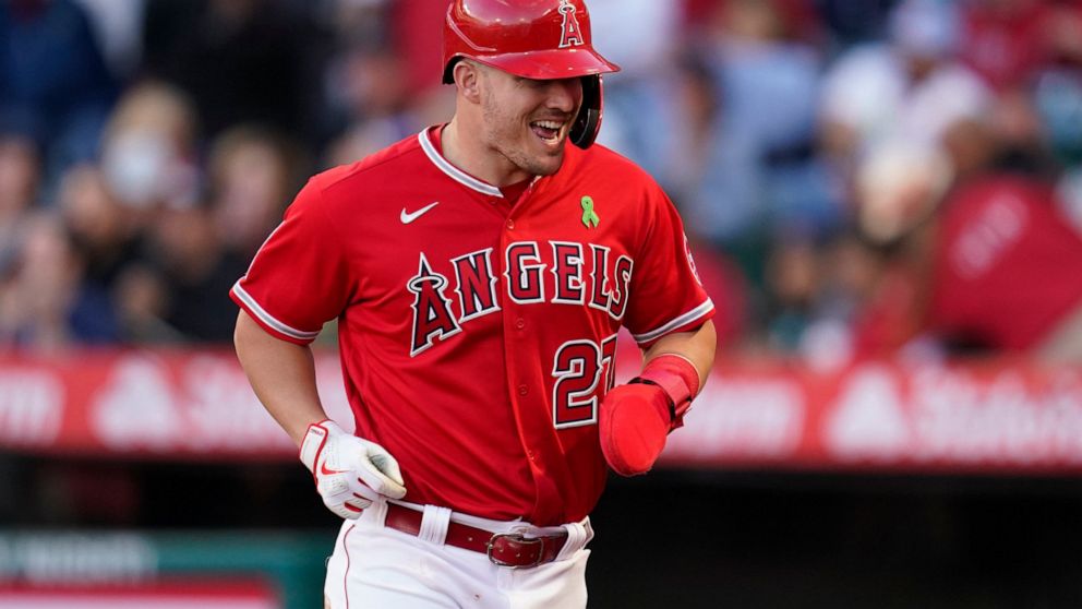 Los Angeles Angels' Mike Trout (27) runs to the dugout after scoring off of a single hit by Jared Walsh during the first inning of a baseball game against the Tampa Bay Rays in Anaheim, Calif., Tuesday, May 10, 2022. (AP Photo/Ashley Landis)
