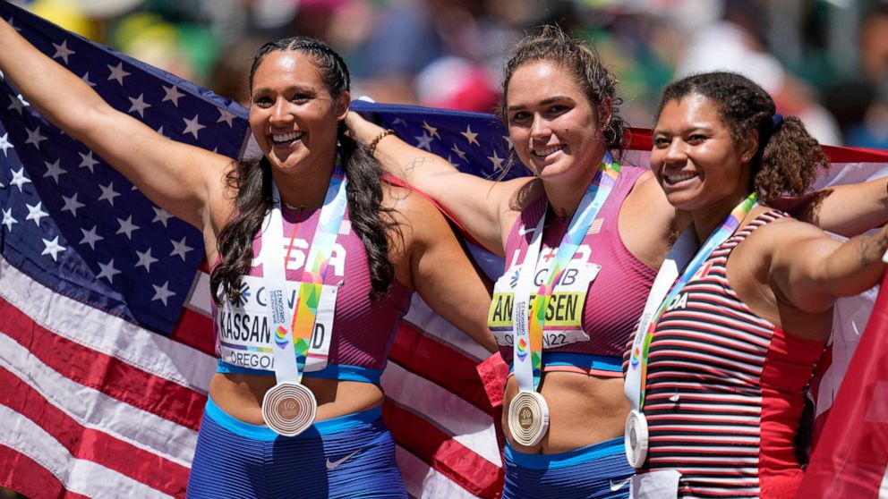 Gold medalist Brooke Andersen, of the United States, center, stands with silver medalist Camryn Rogers, of Canada, right, and bronze medalist Janee' Kassanavoid, of the United States, after the women's hammer throw final at the World Athletics Champi