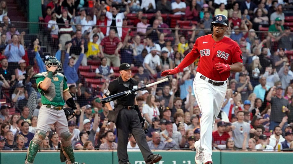 Boston Red Sox's Rafael Devers tosses his bat after hitting a two-run home run, as Oakland Athletics catcher Sean Murphy watches during the second inning of a baseball game at Fenway Park, Wednesday, June 15, 2022, in Boston. (AP Photo/Mary Schwalm)