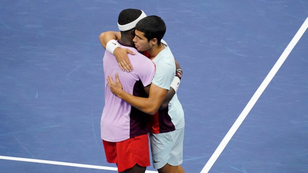 Carlos Alcaraz, of Spain, right, embraces Frances Tiafoe, of the United States, after defeating him in the semifinals of the U.S. Open tennis championships, Friday, Sept. 9, 2022, in New York. (AP Photo/Mary Altaffer)