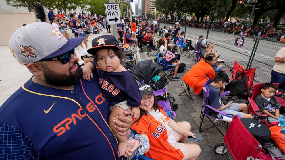 Luis Varela holds his 10-month-old son Joaquin as fans wait for a victory parade for the Houston Astros' World Series baseball championship Monday, Nov. 7, 2022, in Houston. (AP Photo/David Phillip)