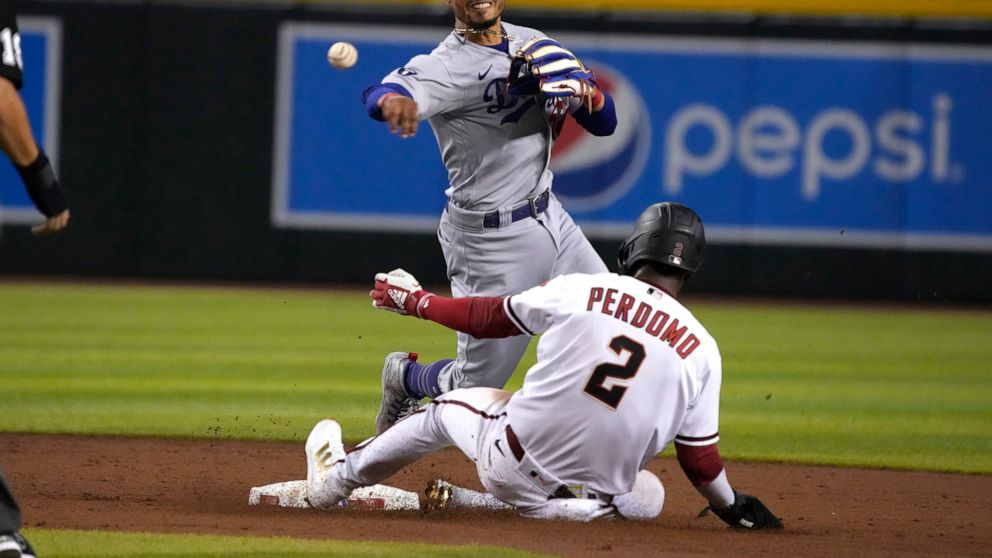 Los Angeles Dodgers second baseman Mookie Betts turns the double play while avoiding Arizona Diamondbacks' Geraldo Perdomo (2) on a ball hit by Carson Kelly in the third inning during a baseball game, Monday, Sept. 12, 2022, in Phoenix. (AP Photo/Ric
