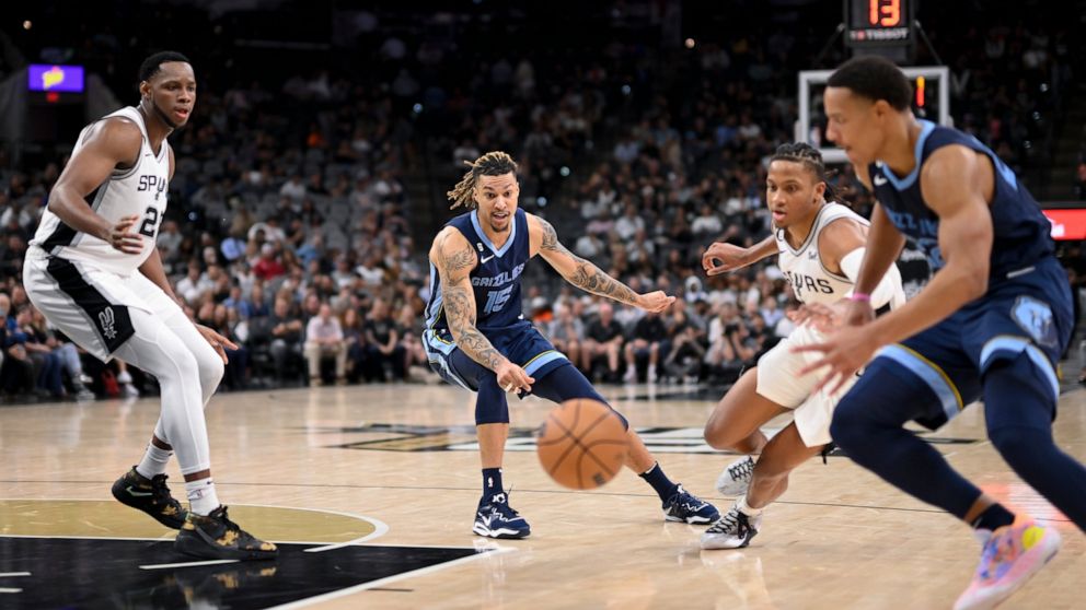 Memphis Grizzlies' Brandon Clarke (15) passes to teammate Desmond Bane, right, between San Antonio Spurs' Romeo Langford and Charles Bassey, left, during the second half of an NBA basketball game, Wednesday, Nov. 9, 2022, in San Antonio. The Grizzlie